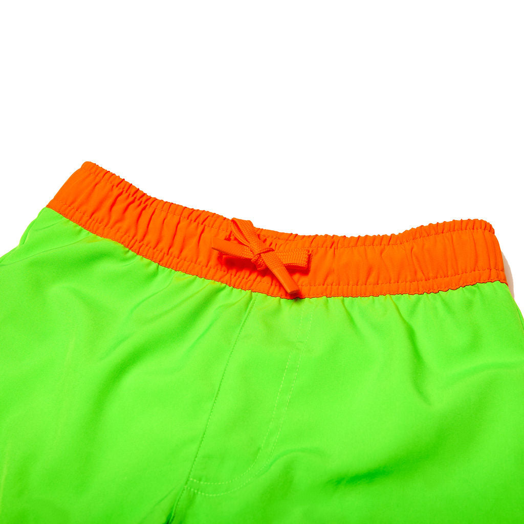 Close up of children's neon green swim trunks with a neon orange waistband that has functional drawstring.