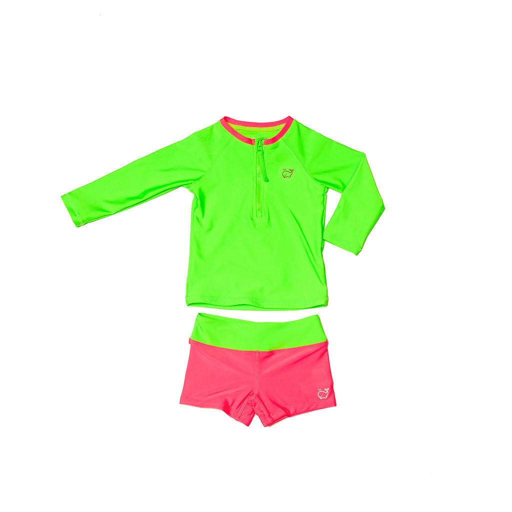 A children’s two-piece swimwear set. On top is a children's neon green rash guard with a neon pink collar and on the bottom is a pair of children’s neon pink euro swim shorts with a neon green waistband.