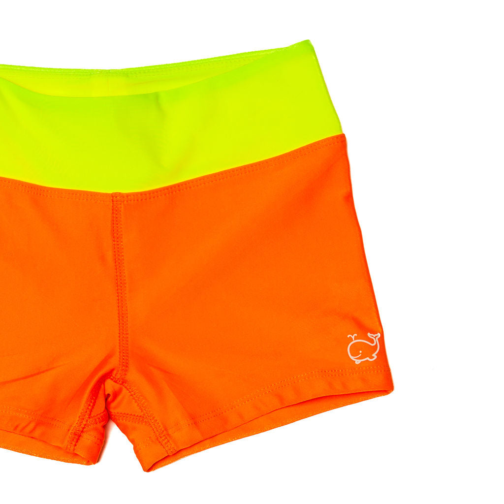 Close up of children's euro swim shorts that are neon orange with a neon yellow waistband.