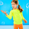 Child playing with bubbles while wearing a neon yellow and neon orange rash guard that features a zipper for easy on off. The child is also wearing neon orange euro swim shorts with a neon yellow waistband.
